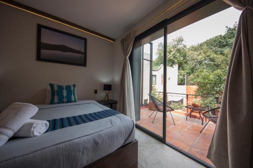 a bedroom with a bed and a balcony with a view at Casa Tonalli Boutique in Mexico City