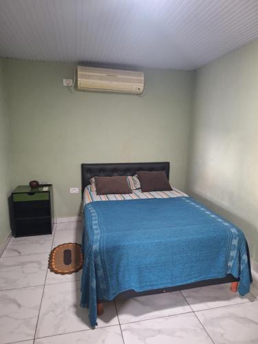 ein Schlafzimmer mit einem Bett mit einer blauen Decke in der Unterkunft Be-Pe in Oberá