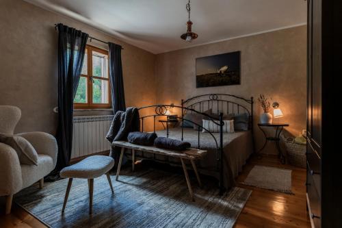a bedroom with a bed and a chair and a window at Villa Boljuncica in Boljun