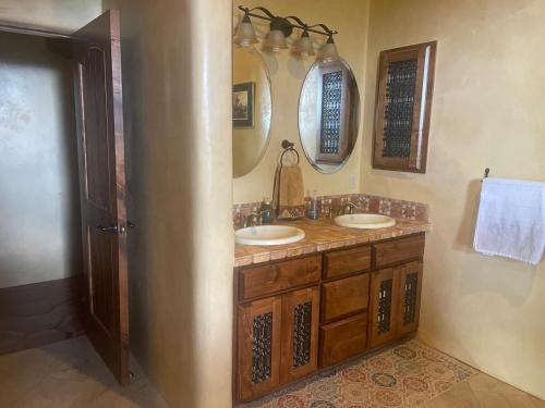 a bathroom with two sinks and two mirrors at "Crows Nest" at Winsor Castle in Valdez
