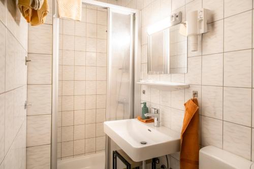 a white bathroom with a sink and a shower at Bauernhof Grussberggut GRATIS THERME & SOMMERBERGBAHN in Bad Hofgastein