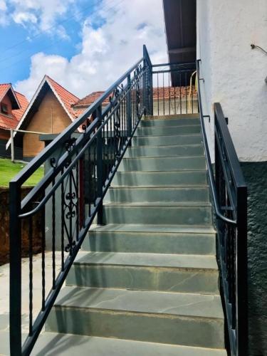 a staircase with metal railings and green steps at Pousada Pinho Verde in Monte Verde