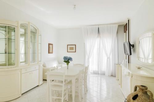a white kitchen with a white table and chairs at Exclusive Large 3 bed room Apartment with Pool Central Sorrento in Sorrento