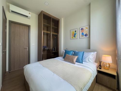 a bedroom with a large white bed with blue pillows at Lovely 2 Bdr Canvas BangTao in Laguna Phuket