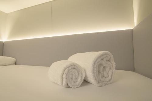 two towels sitting on top of a bed at Hostel Superlativo Trinidad in Málaga