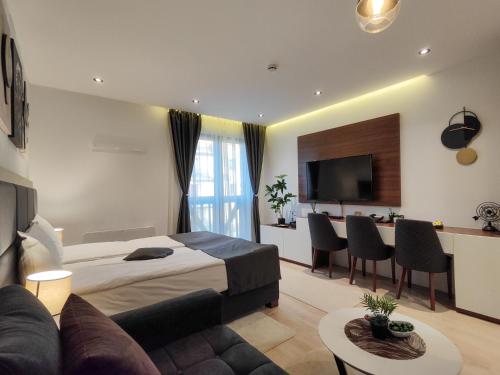 a hotel room with a bed and a couch and a table at Zoned MASLAČAK lux - SPA & Wellness Kopaonik in Kopaonik