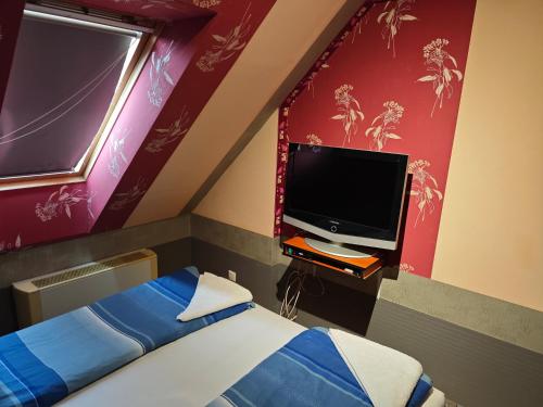 a bedroom with a bed and a flat screen tv at Tommy Apartman in Hajdúszoboszló