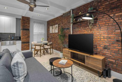 a living room with a couch and a flat screen tv at Bold NYC Stay in Fashionable Nolita in New York