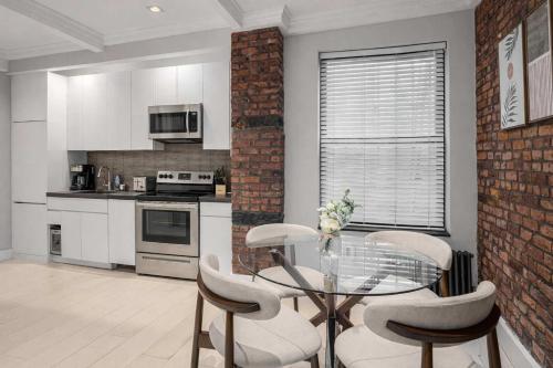 a kitchen with a glass table and chairs at Bold NYC Stay in Fashionable Nolita in New York