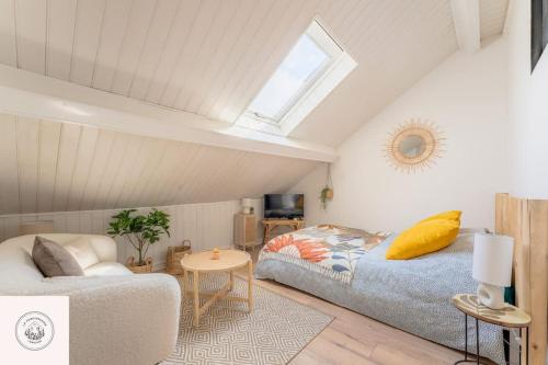 una camera da letto con un letto, un divano e una finestra di Dans les combles d'Eugène a Lens