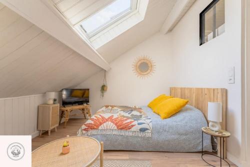 una camera da letto con un letto e un tavolo in una soffitta di Dans les combles d'Eugène a Lens