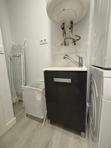 a bathroom with a sink and a washing machine at Marea in Sanxenxo