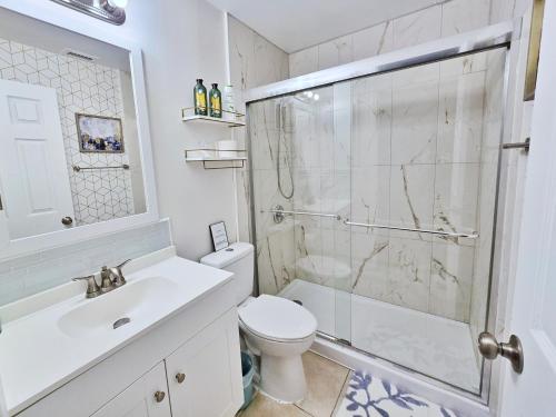 a bathroom with a shower and a toilet and a sink at Sparkling Oasis near Downtown ST Pete/Beach in St. Petersburg