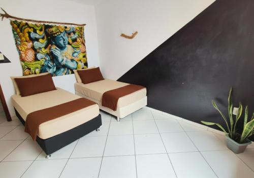 a room with two beds and a painting on the wall at Refúgio na Mata in Lençóis