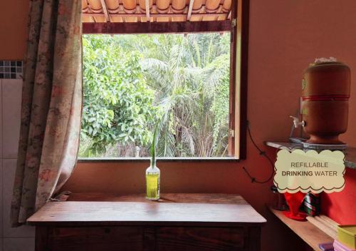 a window in a kitchen with a vase on a table at Refúgio na Mata in Lençóis