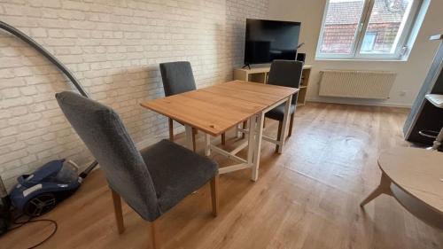 Duplex 4p Arras في أراس: غرفة طعام بها طاولة وكراسي خشبية