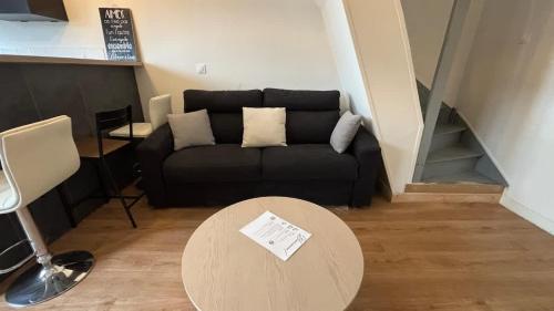 Duplex 4p Arras في أراس: غرفة معيشة مع أريكة سوداء وطاولة