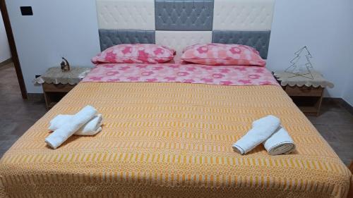 a large bed with two pairs of slippers on it at Casa vacanze San Gianni in Ardore Marina