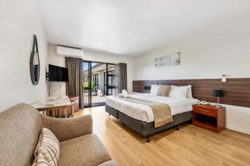a hotel room with a bed and a couch at Auckland Airport Easy Hotel in Auckland