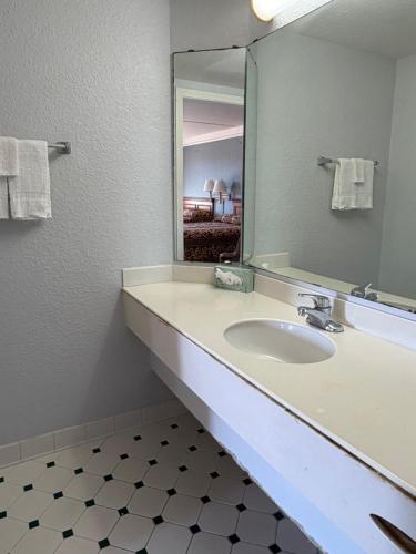a bathroom with a sink and a mirror at America's Inn Houston/Stafford /Sugarland in Houston