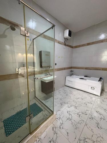 a bathroom with a glass shower and a sink at Fukusu II in Ikuata