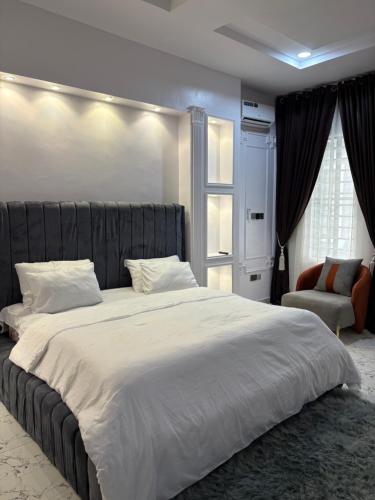 a bedroom with a large bed and a chair at Fukusu II in Ikuata