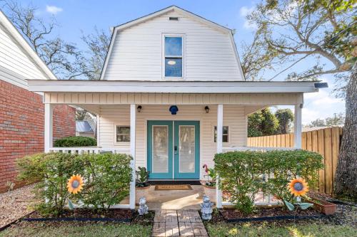 a white house with a blue door at Beach Barn - 5min to Pcola Beach , Full Kitchen in Gulf Breeze