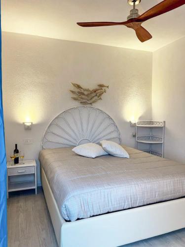 a bedroom with a bed with a ceiling fan at Smeralda Apartment - Golfo Aranci in Golfo Aranci