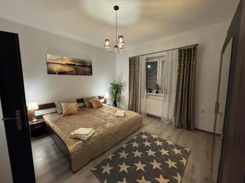 a bedroom with a large bed and a chandelier at Apartment PMS in Veľká Mača