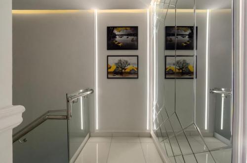 a bathroom with a glass corridor with pictures on the wall at Olaz holmes in Lagos