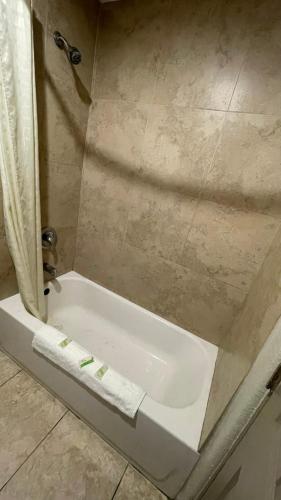 a white bath tub in a bathroom with a shower at Western Lodge Phoenix Airport/Downtown in Phoenix