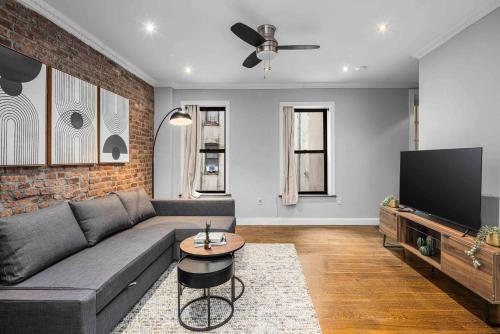 a living room with a couch and a flat screen tv at Modern Manhattan Retreat Near Central Park in New York