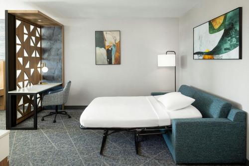 a bedroom with a bed and a couch and a desk at SpringHill Suites by Marriott Atlanta Covington in Covington