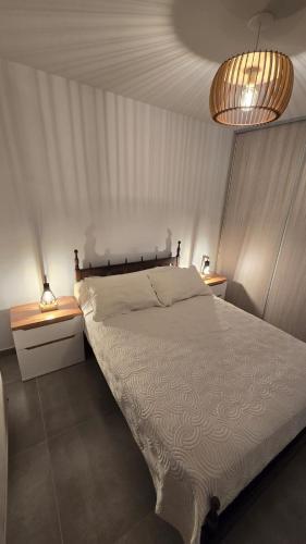 a bedroom with a white bed and two night stands at Departamento BARBÚ in Villa María