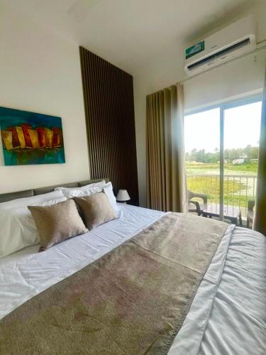 a bedroom with a large bed and a balcony at Santorini Transit hotel in Negombo
