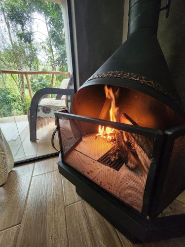 a fireplace in a room with a fire in it at Studio Mata dos Curiós in Petrópolis