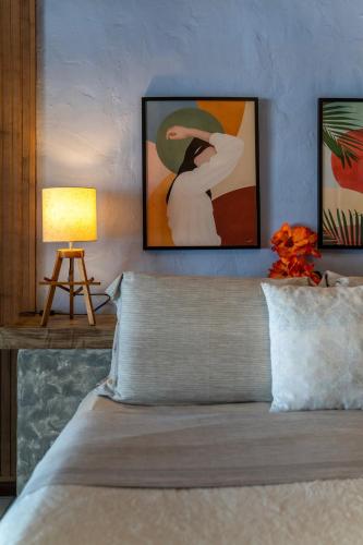 a bedroom with a bed and a table with a lamp at Pousada dos Gravatás in Búzios