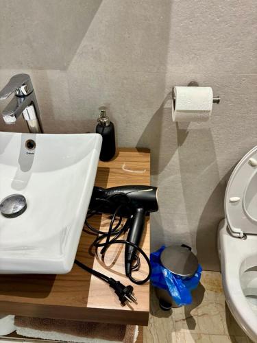 a bathroom with a white sink and a toilet at Le murmure in Oulad Akkou