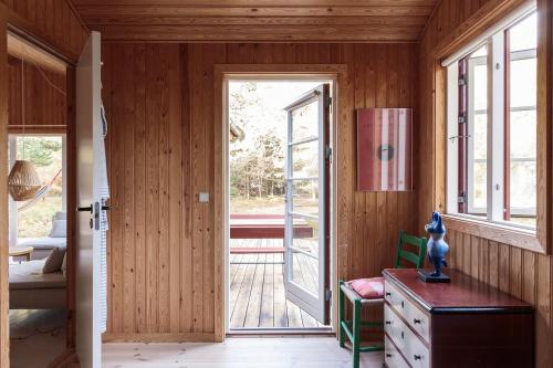a room with a door leading to a deck with a porch at Authentic Summerhouse Near The Beach in Rørvig
