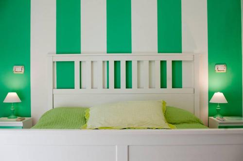 a bedroom with green and white walls and a bed at O' Paese E Masaniello in Naples