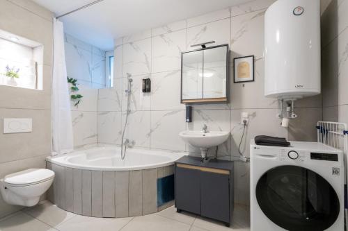 a bathroom with a tub and a toilet and a sink at COY Apartments Kapfenberg - Spacious Stays for Companies, Groups & Workers in Kapfenberg