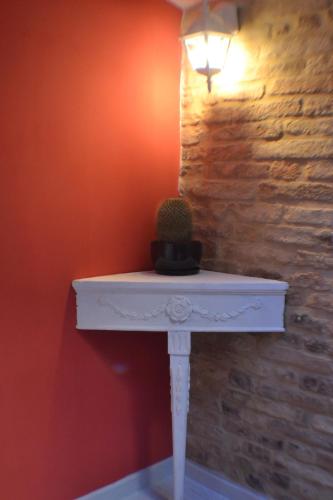 a white table with a cactus on it next to a wall at B&B La Lanterna in Fermo