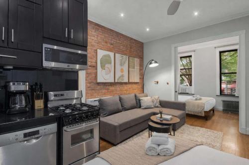 a kitchen and living room with a couch and a stove at Chic NYC Retreat by Central Park in New York