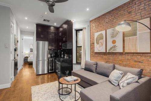 a living room with a couch and a brick wall at Chic NYC Retreat by Central Park in New York