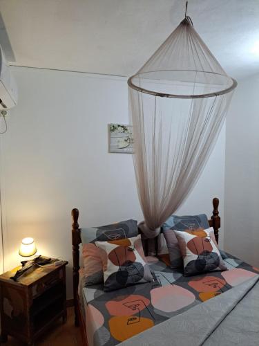 a bedroom with a bed with a canopy at MAISON DE VACANCES KAZ A LOLO in Port-Louis