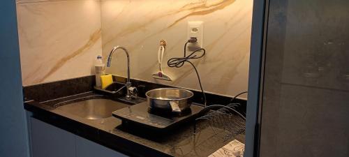 a kitchen counter with a sink and a whisk at Studio Luxuoso frente Mar in Salvador