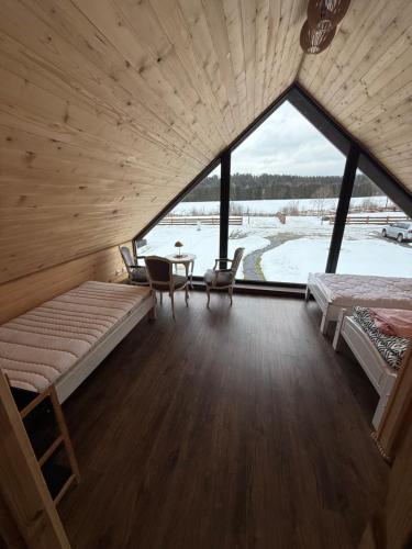 a room with a bed and a table and a window at Domek pod Besidą in Czarna