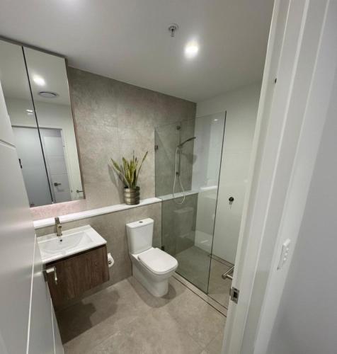 a bathroom with a toilet and a shower and a sink at Cozy Suite in Schofields in Schofields