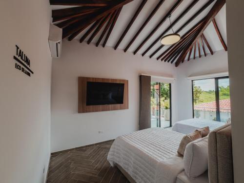 a bedroom with a bed and a tv on the wall at Antara Resort in Alcalá