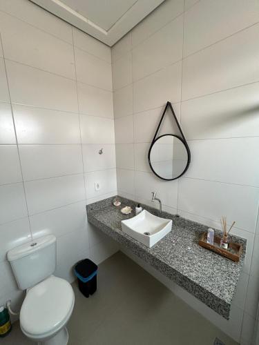 a bathroom with a white toilet and a sink at Apartamento Centro 02 in Vilhena